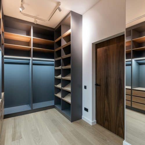 Spacious modern walk-in closet with wooden shelves and sleek finishes.