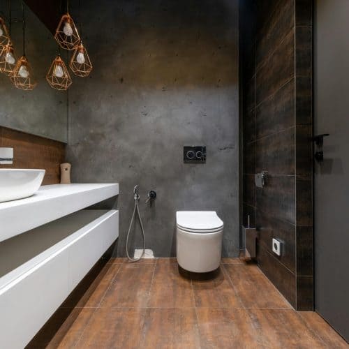 Sleek modern bathroom featuring a minimalist sink and elegant hanging lights.